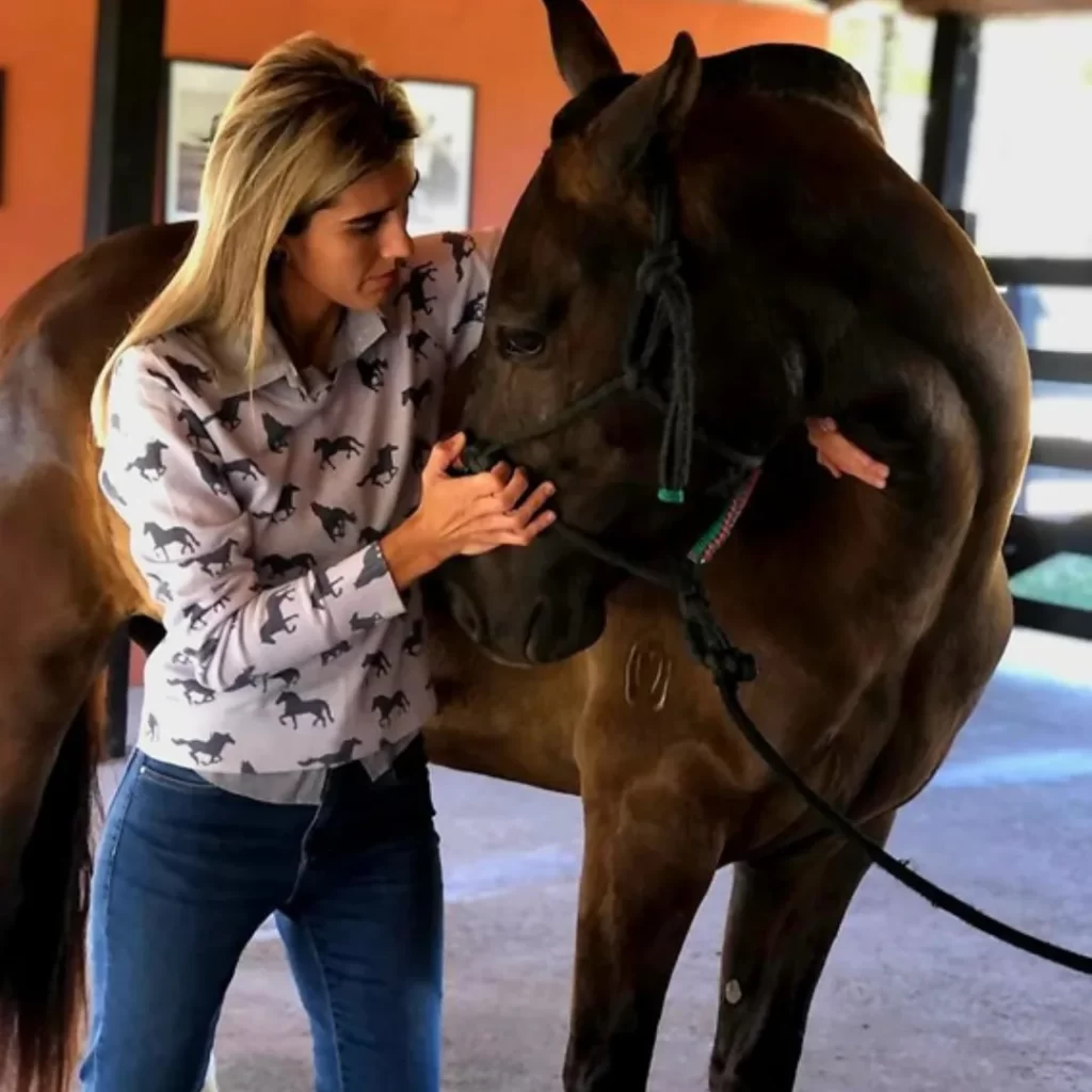 Dra. Thamires Lara Rezende aplicando técnica de alongamento em equino durante aula prática de fisiatria no Instituto VetSociety