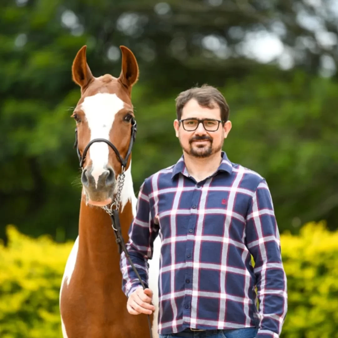 Dr. Samuel Simonato segurando a rédea de um cavalo durante avaliação de mobilidade articular em sessão de fisioterapia equina no Instituto VetSociety